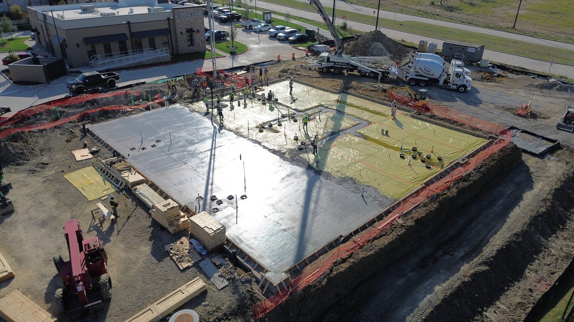 Aerial view of a construction site with workers pouring concrete. Aerial view of a construction site with workers pouring concrete.